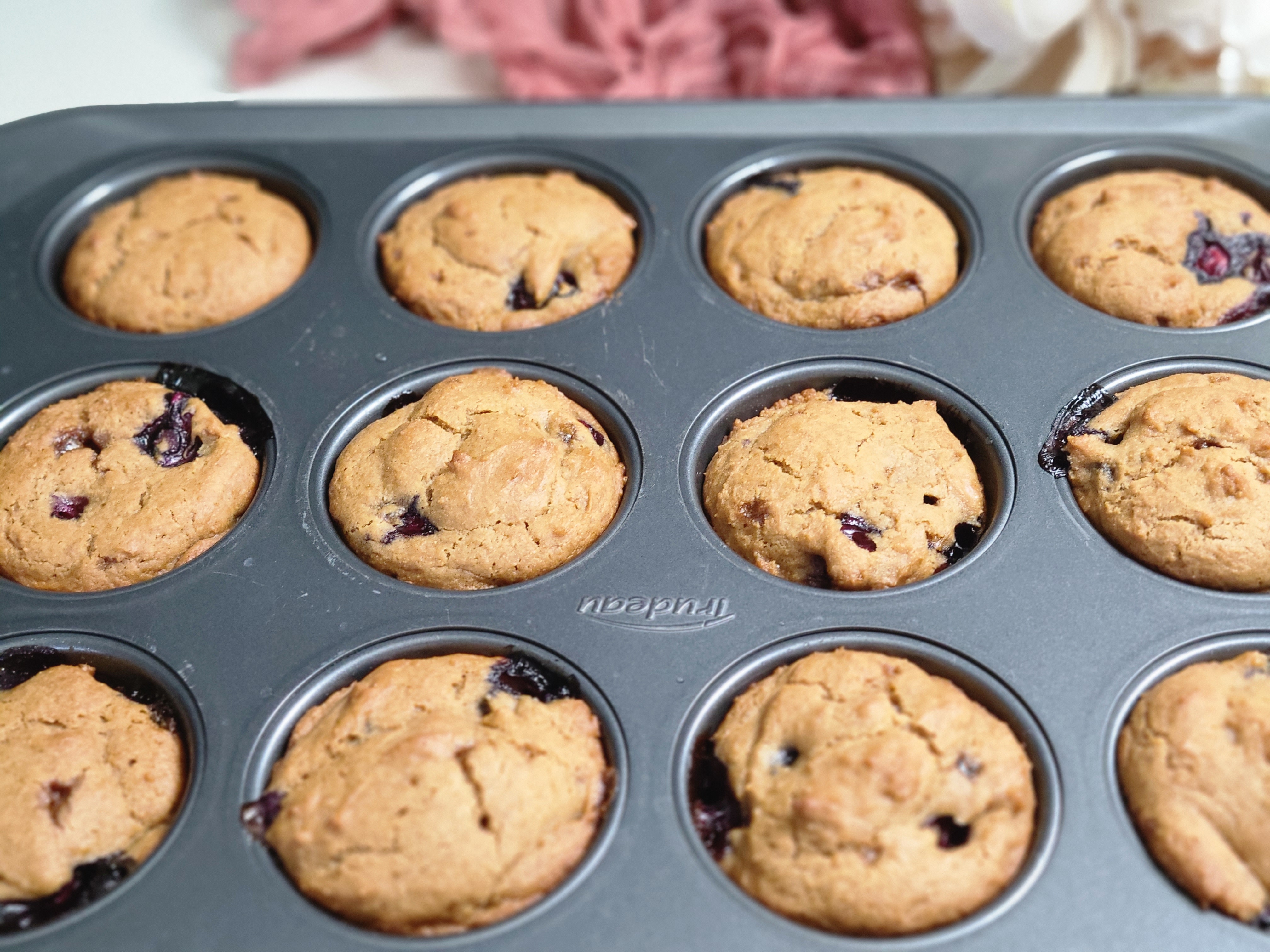 Baked blueberry muffins in a muffin tin.