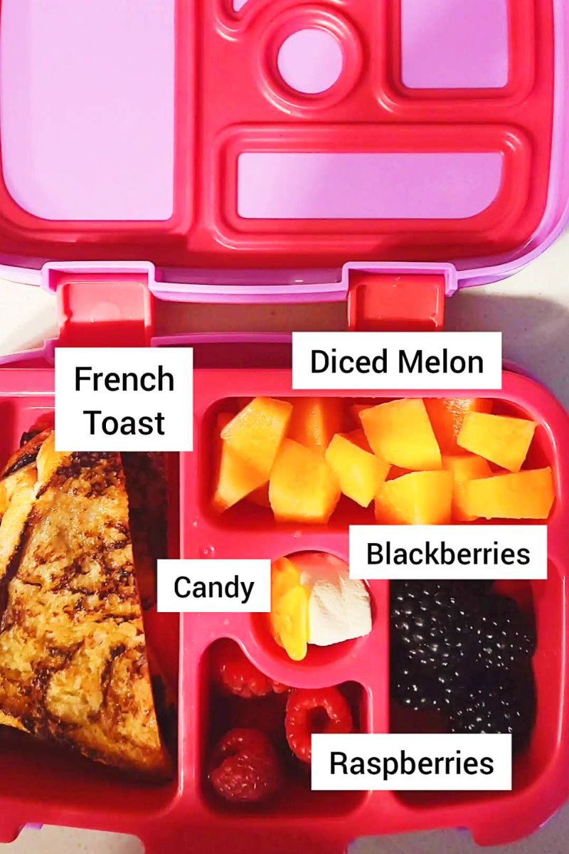 Lunchbox with french toast, melon and blackberries.