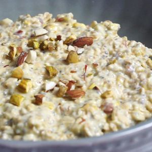 Overnight oats topped with kesar and nuts in a bowl.