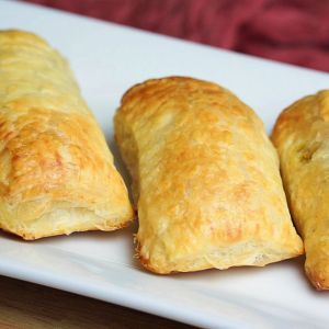 Aloo puffs stacked on a white tray.