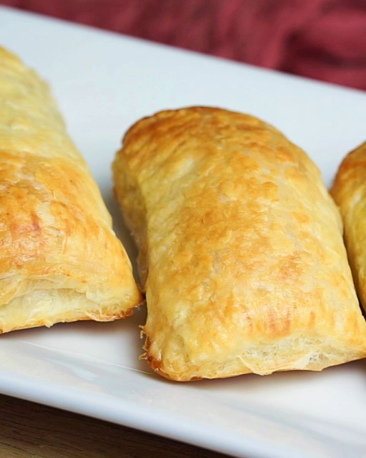 Aloo puffs stacked on a white tray.