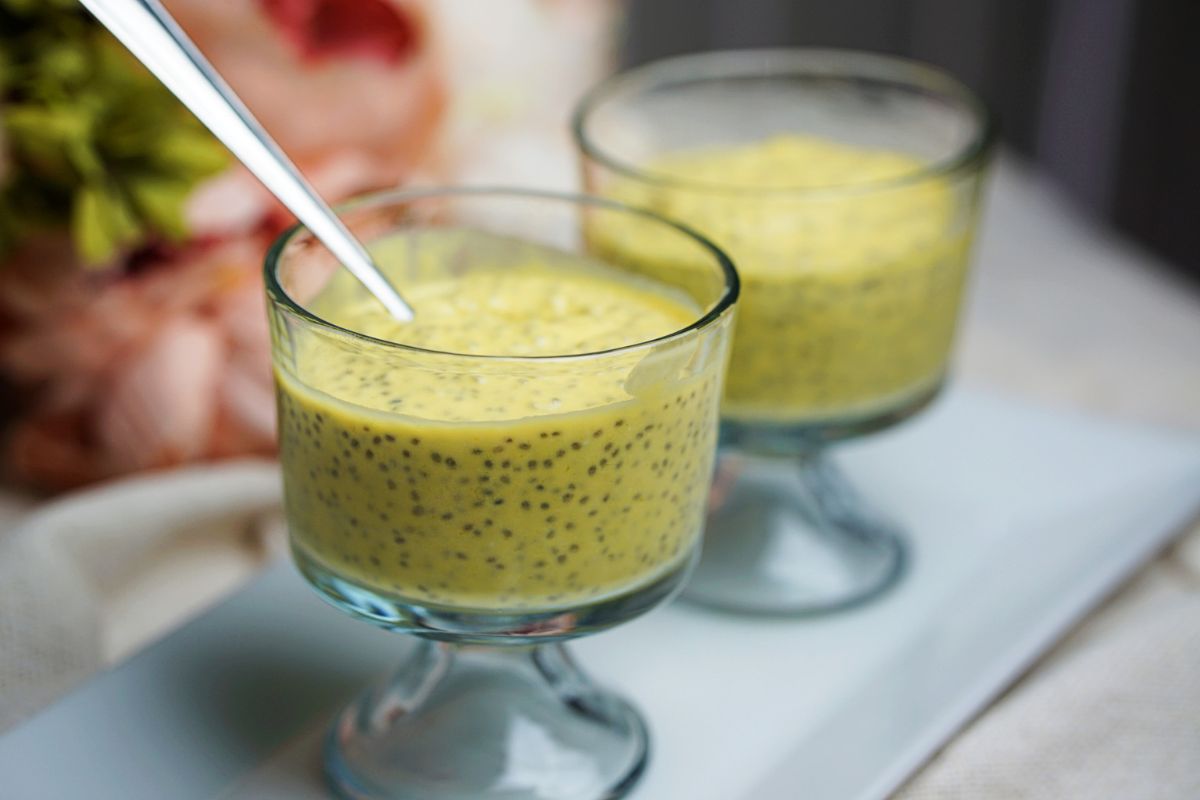 Mango chia pudding in a cup with spoon.